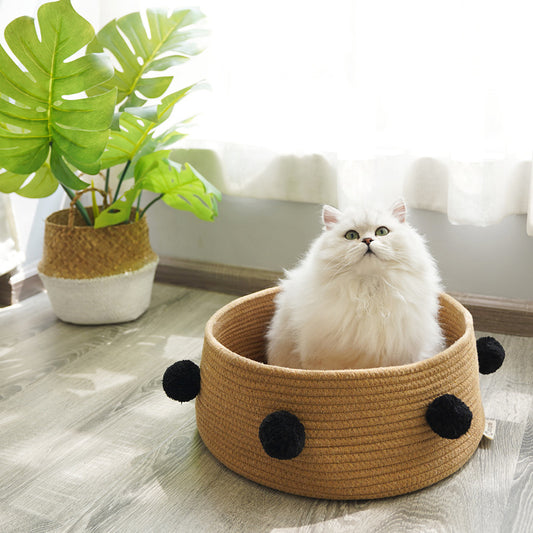 Cesta nórdica de algodón marrón con un gato dentro, en un salón luminoso