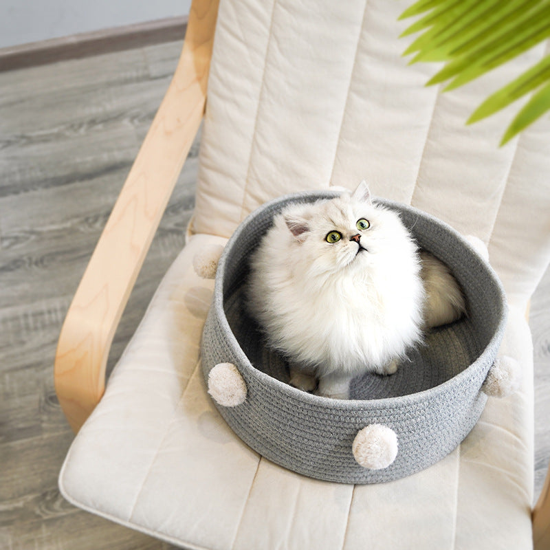 Gato persa en la cesta nórdica gris sobre un sillón
